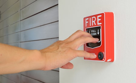 hand pulling the fire alarm at a business