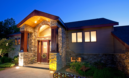 The exterior of a home with the lights on at night